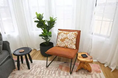 a chair in a living room with a pillow on it at Renovated home seconds from town in Woodstock