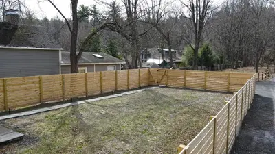 a wooden fence in a yard next to a house at Renovated home seconds from town in Woodstock