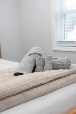 a pile of towels sitting on top of a bed at R&C Getaway in Greenville