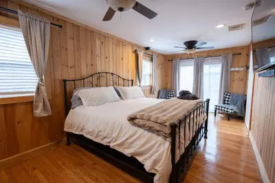 a bedroom with a bed in a room with wooden walls at R&C Getaway in Greenville