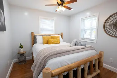 a bedroom with a wooden bed with a ceiling fan at R&C Getaway in Greenville