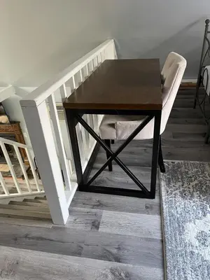 a table and a chair in a room with stairs at Fully updated home with hot tub in amenity filled community in Lackawaxen