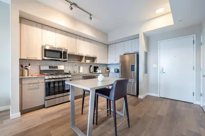 a kitchen with a table and a stove and refrigerator at Gorgeous Apt w Harbor Views & Gym in South End