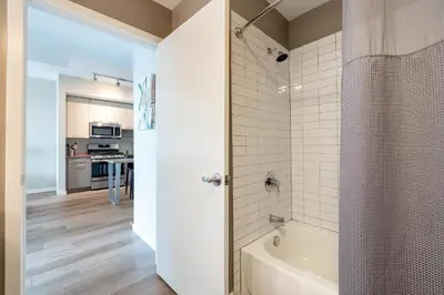 a bathroom with a bath tub and a kitchen at Gorgeous Apt w Harbor Views & Gym in South End