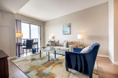 a living room with a couch and a table at Gorgeous Apt w Harbor Views & Gym in South End
