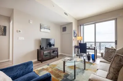a living room with a couch and a table and a tv at Gorgeous Apt w Harbor Views & Gym in South End