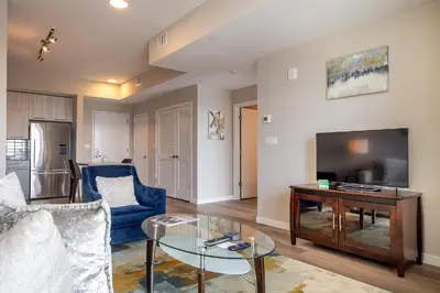 a living room with a couch and a table and a tv at Gorgeous Apt w Harbor Views & Gym in South End