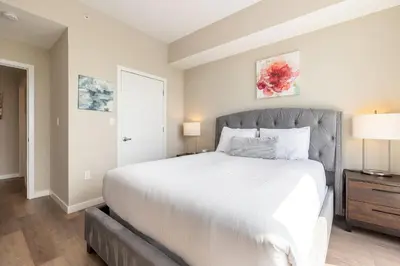 a bedroom with a large white bed and a window at Gorgeous Apt w Harbor Views & Gym in South End