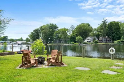 two chairs sitting in the grass next to a lake at Modern Lakefront Retreat w King Bed in Saugerties