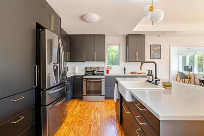 a kitchen with black cabinets and white counter tops at Modern Lakefront Retreat w King Bed in Saugerties