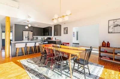 a kitchen and dining room with a wooden table and chairs at Modern Lakefront Retreat w King Bed in Saugerties