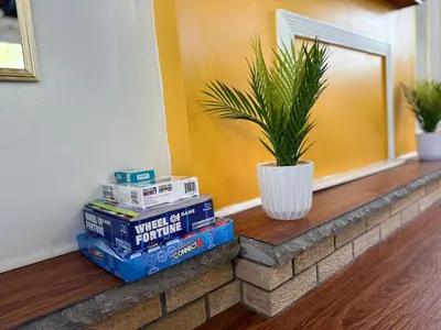 a stack of books on a brick ledge with a potted plant at Cozy Pocono Escape in Tobyhanna