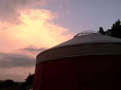 a silo with a cloudy sky in the background at Modern Countryside Yurt Rental in Waterville, Upstate New York in Waterville