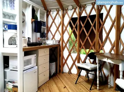 a kitchen with a tent with a table and a microwave at Modern Countryside Yurt Rental in Waterville, Upstate New York in Waterville