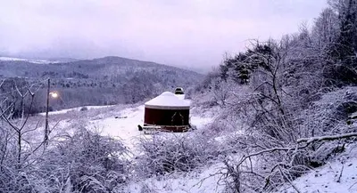 a building covered in snow on a snow covered hill at Modern Countryside Yurt Rental in Waterville, Upstate New York in Waterville