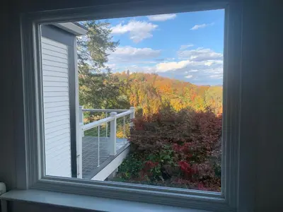 a window with a view of a balcony with trees at The Huron stunning water views and family home vibes in Milton in Milton