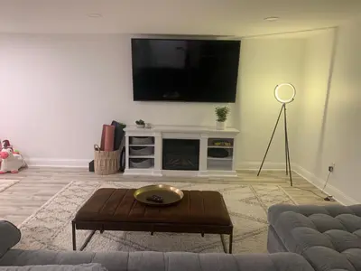 a living room with a flat screen tv on a wall at The Huron stunning water views and family home vibes in Milton in Milton