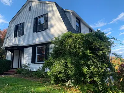 a white house with black windows and a bush at The Huron stunning water views and family home vibes in Milton in Milton