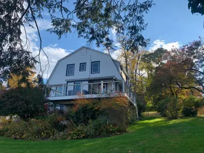 a large house on a hill with a yard at The Huron stunning water views and family home vibes in Milton in Milton