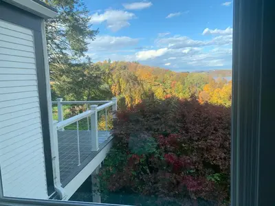 a balcony with a view of the fall foliage at The Huron stunning water views and family home vibes in Milton in Milton