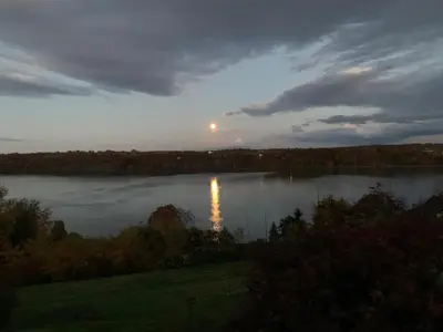 a view of a lake with the sun reflecting on the water at The Huron stunning water views and family home vibes in Milton in Milton