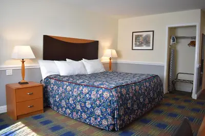 a bedroom with a bed and a night stand with two lamps at East Norwich Inn in East Norwich