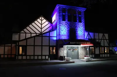 a building with purple lights on it at night at East Norwich Inn in East Norwich