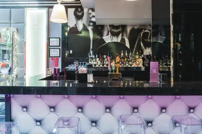 a bar with purple chairs in front of it at Riu Plaza New York Times Square in New York