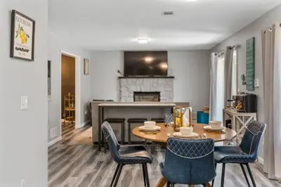 a dining room with a table and chairs and a fireplace at Emerald Lakes Poconos Retreat Game Room, Firepit & Sleeps 10 in Long Pond