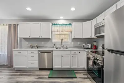 a white kitchen with white cabinets and a sink at Emerald Lakes Poconos Retreat Game Room, Firepit & Sleeps 10 in Long Pond