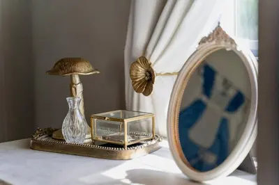 a table with a mirror and a vase and a lamp at Alice in Wonderland Pocono Home in Honesdale