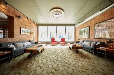 a large living room with couches and tables and windows at Hotel on North in Pittsfield