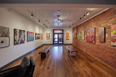a room with benches and paintings on the walls at Hotel on North in Pittsfield