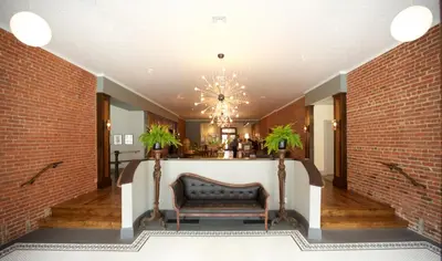 a lobby with a couch and a brick wall at Hotel on North in Pittsfield