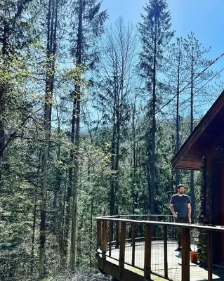 a man standing on the deck of a cabin at Stunning Catskills Cabin in Margaretville