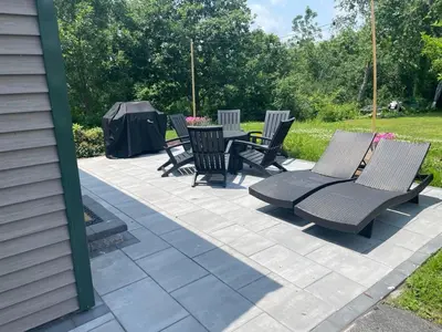 a group of chairs and tables on a patio at Lakefront Luxury at Stony Pointe in Ballston Spa