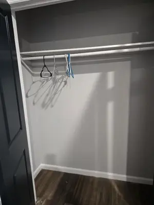 a closet with hangers and utensils on a wall at favour family house in Newark