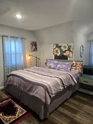 a bedroom with a large bed with purple sheets at Rose room 8 in Newark