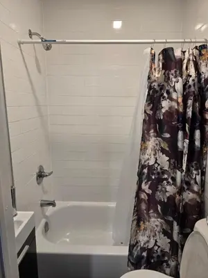a bathroom with a tub and a toilet and a shower curtain at Rose room 8 in Newark