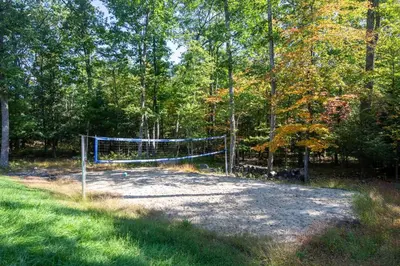 a volleyball net in the middle of a forest at Log House Chalet, Volleyball field, Sauna, Hot Tub in Henryville