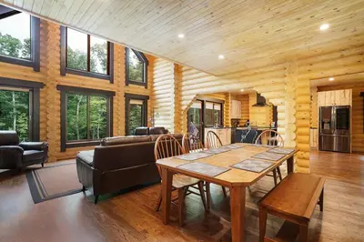 a living room with a table and a couch at Log House Chalet, Volleyball field, Sauna, Hot Tub in Henryville