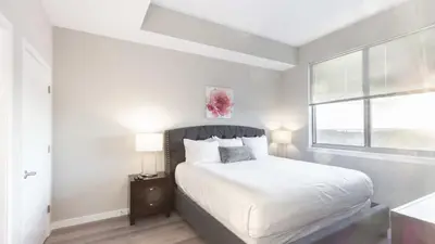 a white bedroom with a bed and a window at Modern Apartment In Harbor Point in South End