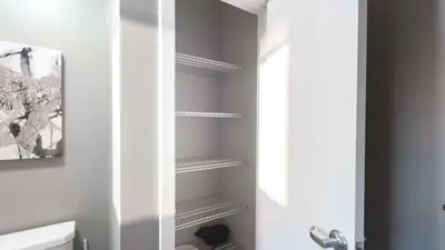 a bathroom with a toilet and some shelves at Modern Apartment In Harbor Point in South End