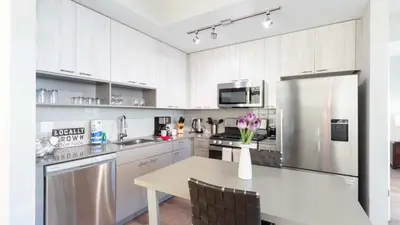 a white kitchen with a table and a refrigerator at Modern Apartment In Harbor Point in South End