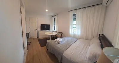 a bedroom with a bed and a table and a television at Astoria, steps away from Manhattan in Astoria