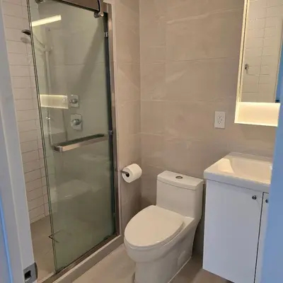 a bathroom with a toilet and a glass shower at Astoria, steps away from Manhattan in Astoria
