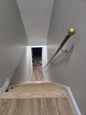 a stairway with a metal rail and a wooden floor at Astoria, steps away from Manhattan in Astoria