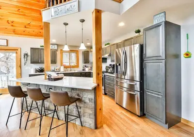 a kitchen with a large island with bar stools at Lakeside Catskills Escape - Soak, Sip, Stargaze in Cairo
