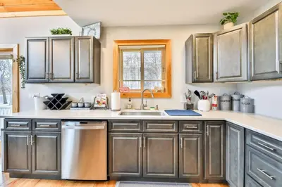 a kitchen with gray cabinets and a sink at Lakeside Catskills Escape - Soak, Sip, Stargaze in Cairo