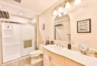 a bathroom with a toilet and a sink and a mirror at Lakeside Catskills Escape - Soak, Sip, Stargaze in Cairo